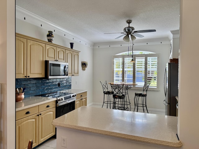kitchen featuring tasteful backsplash, light brown cabinets, a ceiling fan, crown molding, and stainless steel appliances