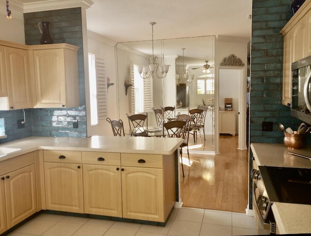 kitchen with crown molding, light brown cabinetry, light countertops, stainless steel appliances, and decorative backsplash