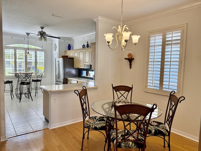 dining space with crown molding, ceiling fan with notable chandelier, baseboards, and light wood-style floors