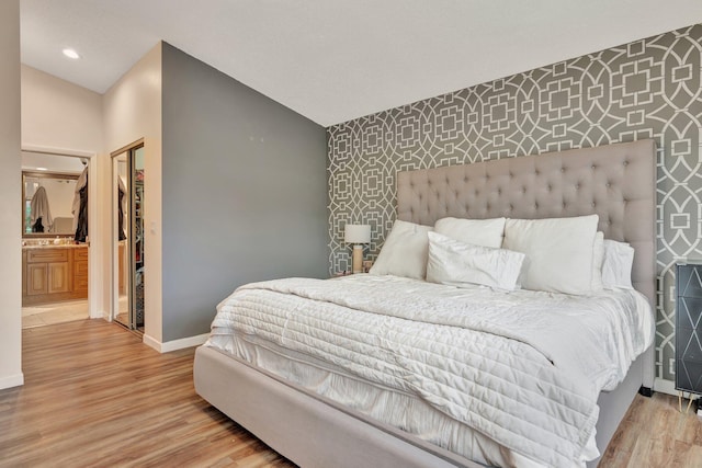 1048 Siena Oaks Cir E, Palm Beach Gardens, FL 33410 - bedroom with baseboards, an accent wall, light wood-type flooring, and wallpapered walls
