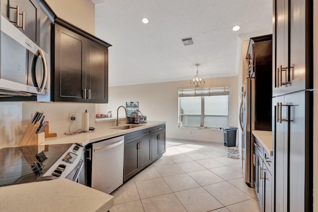 kitchen featuring light tile patterned floors, visible vents, stainless steel appliances, crown molding, and a sink