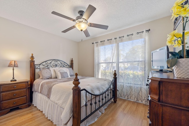 bedroom featuring a textured ceiling, ceiling fan, and light hardwood / wood-style floors