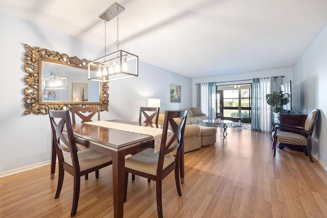 dining space featuring light hardwood / wood-style flooring and a textured ceiling