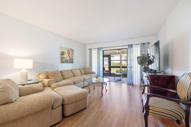 living room with a textured ceiling and light wood-type flooring