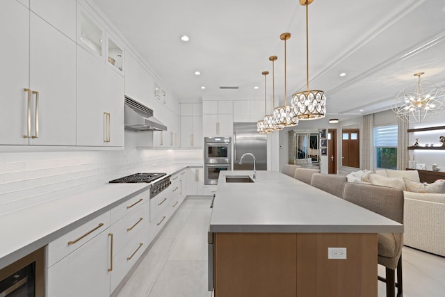 kitchen with white cabinetry, a large island, hanging light fixtures, and appliances with stainless steel finishes