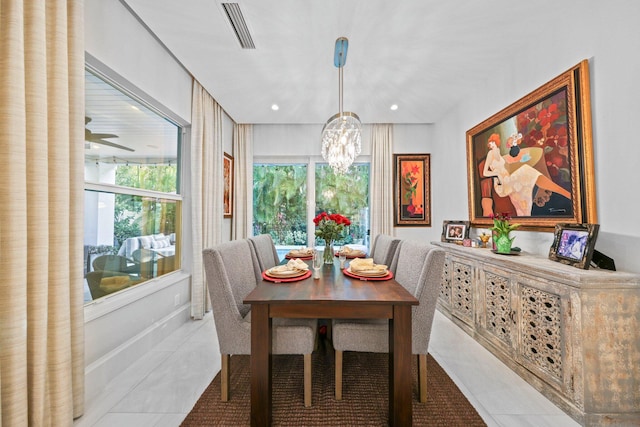 tiled dining room with an inviting chandelier