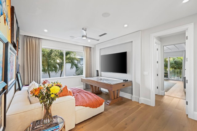 living room with ceiling fan, plenty of natural light, and light hardwood / wood-style floors