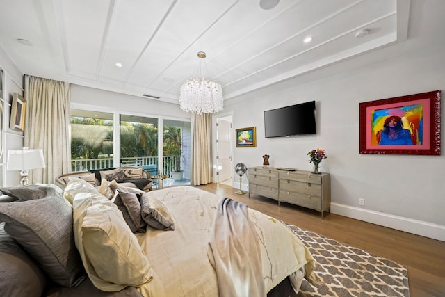 bedroom featuring hardwood / wood-style flooring, access to outside, and a chandelier