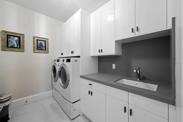 laundry room featuring cabinets, separate washer and dryer, and sink