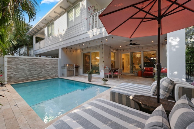 view of swimming pool with area for grilling, a grill, a patio, and ceiling fan