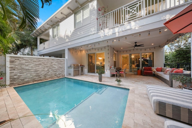 view of pool with a patio, an outdoor kitchen, an outdoor hangout area, and ceiling fan