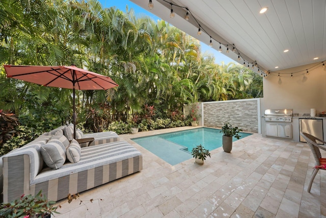 view of pool featuring an outdoor kitchen, area for grilling, and a patio area