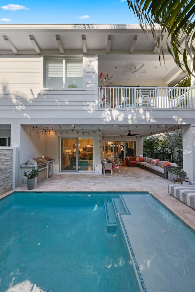 rear view of house featuring an outdoor kitchen, a balcony, ceiling fan, an outdoor living space, and a patio