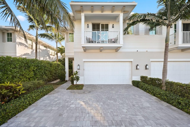 view of front of home with a garage and a balcony