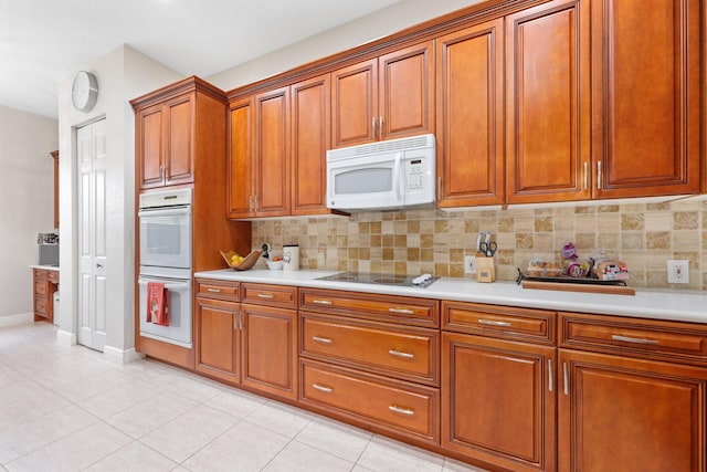 kitchen featuring light tile patterned flooring, white appliances, and decorative backsplash