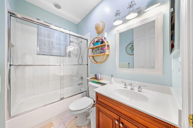 full bathroom featuring vanity, tile patterned floors, shower / bath combination with glass door, and toilet