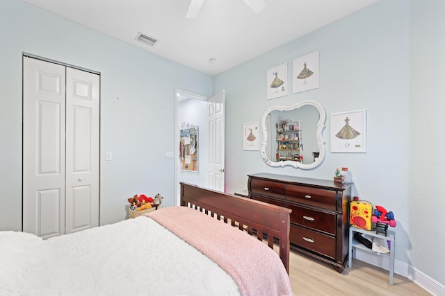 bedroom with light hardwood / wood-style flooring, ceiling fan, and a closet