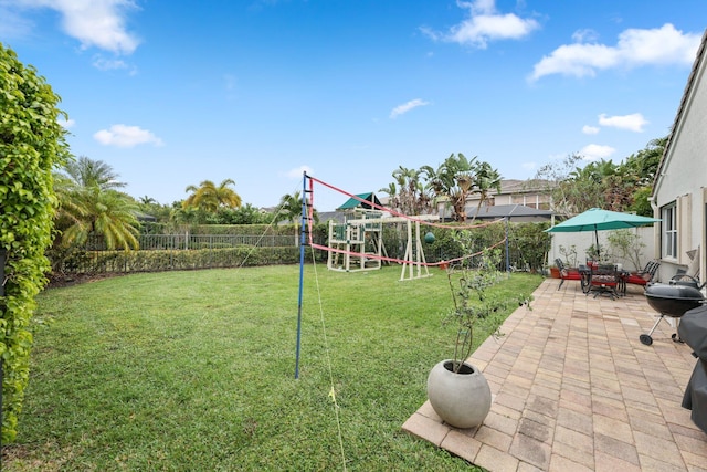 view of yard featuring a playground and a patio