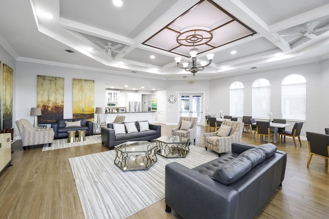 living room featuring crown molding, coffered ceiling, and ceiling fan with notable chandelier