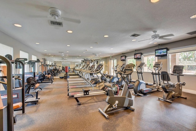 exercise room with ceiling fan and a textured ceiling