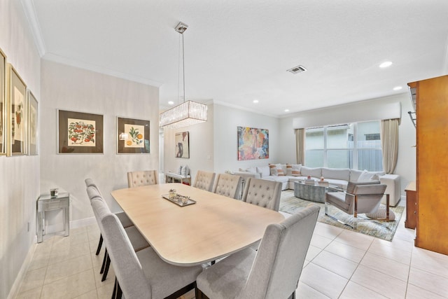 dining space with crown molding and light tile patterned floors