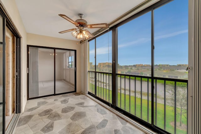 unfurnished sunroom featuring a ceiling fan