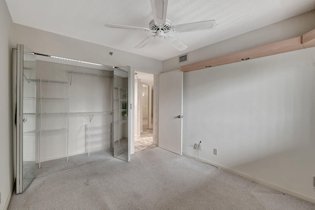 unfurnished bedroom featuring baseboards, visible vents, ceiling fan, carpet floors, and a closet