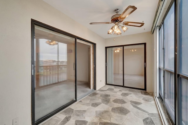 unfurnished sunroom featuring a ceiling fan