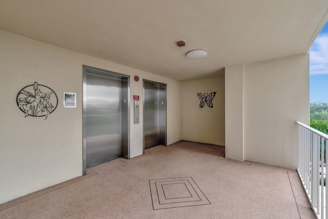 unfurnished room featuring light speckled floor and elevator