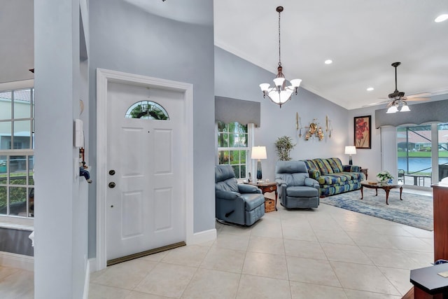 tiled entrance foyer featuring ceiling fan with notable chandelier, plenty of natural light, ornamental molding, and a water view