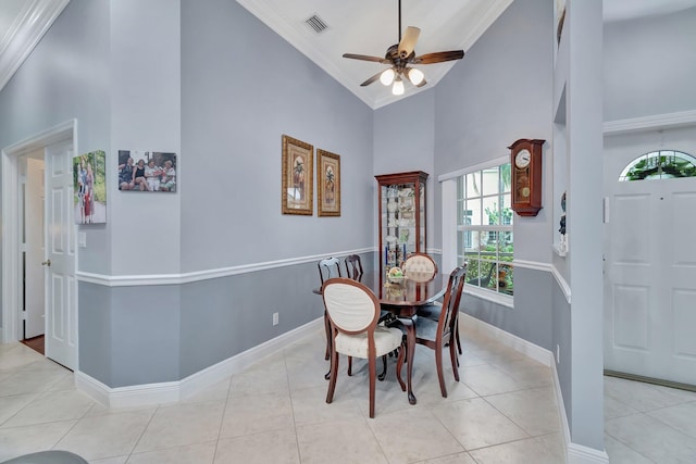 dining space with crown molding, light tile patterned flooring, ceiling fan, and high vaulted ceiling