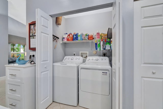 washroom with light tile patterned floors and washer and dryer