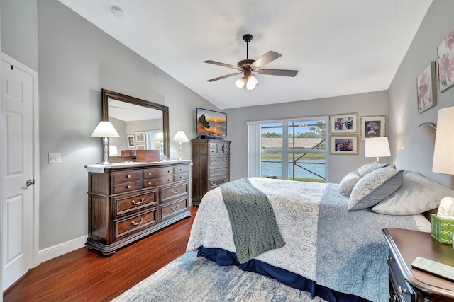 bedroom featuring dark hardwood / wood-style flooring, access to exterior, vaulted ceiling, and ceiling fan