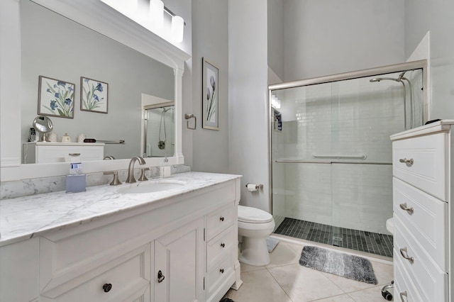 bathroom featuring vanity, toilet, a shower with door, and tile patterned flooring