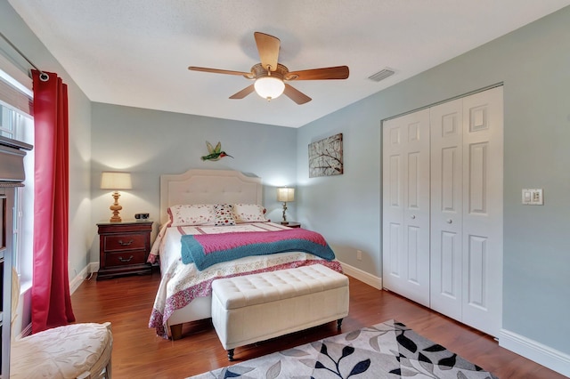 bedroom with dark hardwood / wood-style flooring, ceiling fan, and a closet