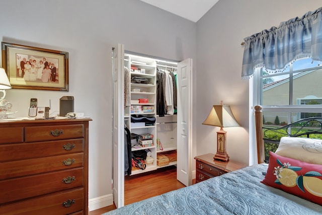 bedroom with light hardwood / wood-style floors and a closet