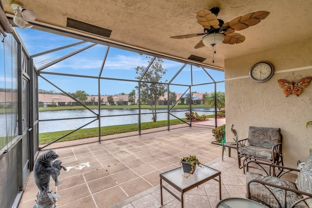 unfurnished sunroom with a water view and ceiling fan