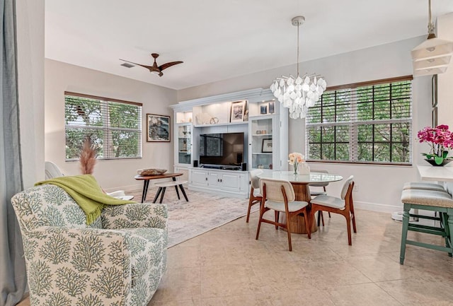 dining space featuring light tile patterned flooring, baseboards, and ceiling fan with notable chandelier