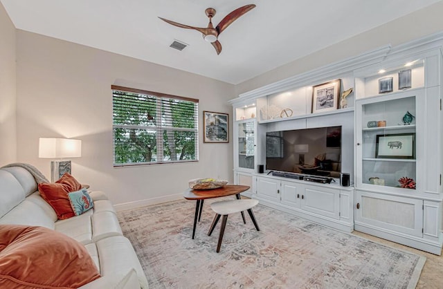 living room with visible vents, a ceiling fan, and baseboards