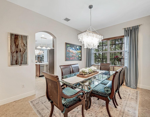 dining space featuring arched walkways, a notable chandelier, visible vents, and baseboards