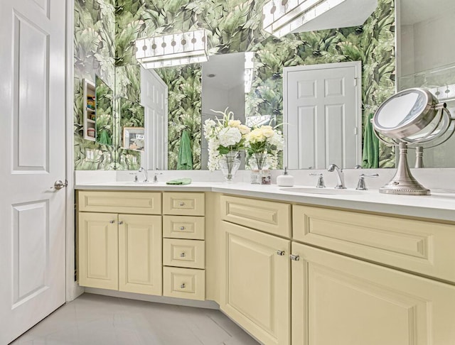 full bathroom with double vanity, a sink, and wallpapered walls