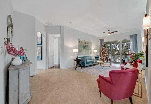 living room featuring a ceiling fan and baseboards