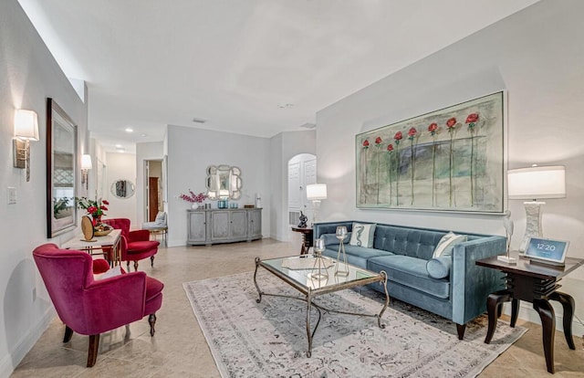 living room with baseboards and arched walkways