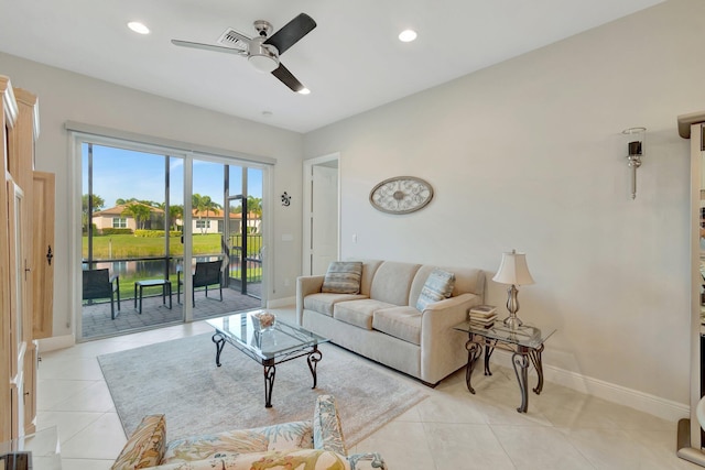 tiled living room featuring ceiling fan and a water view