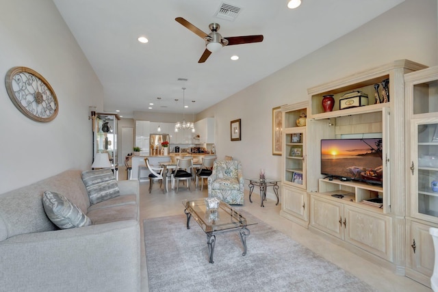 living room with ceiling fan with notable chandelier