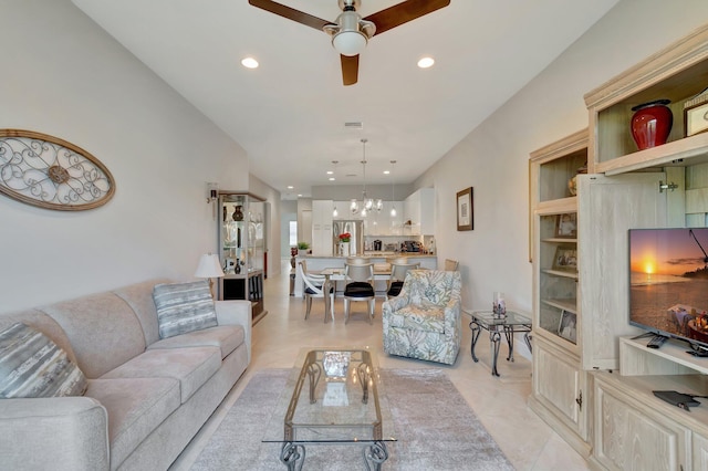 living room with light tile patterned flooring and ceiling fan with notable chandelier