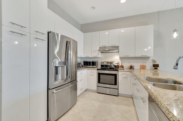 kitchen featuring sink, white cabinetry, stainless steel appliances, light stone countertops, and light tile patterned flooring