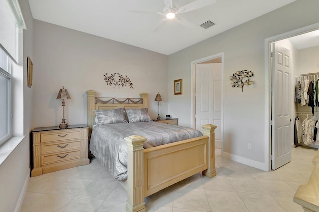 tiled bedroom with a walk in closet, a closet, and ceiling fan