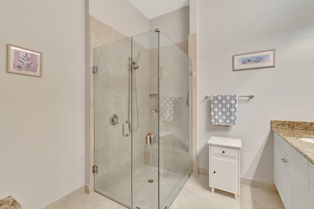 bathroom with a shower with door, vanity, and tile patterned flooring