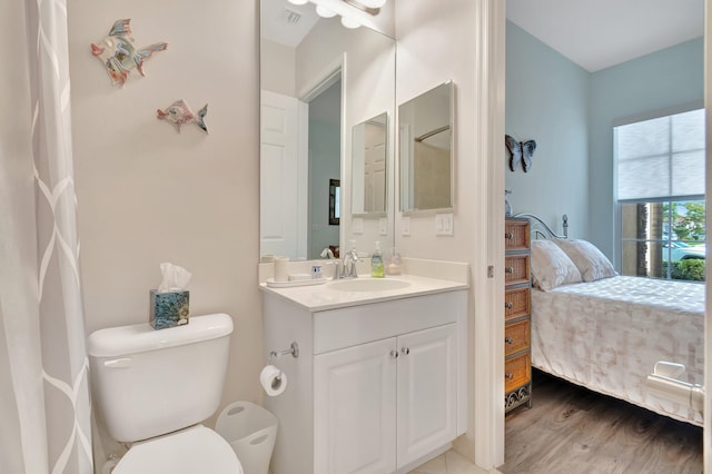 bathroom with hardwood / wood-style flooring, vanity, and toilet